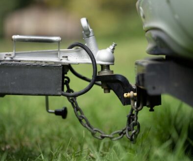 Tow vehicle attached to a trailer with coupler and safety chains visible